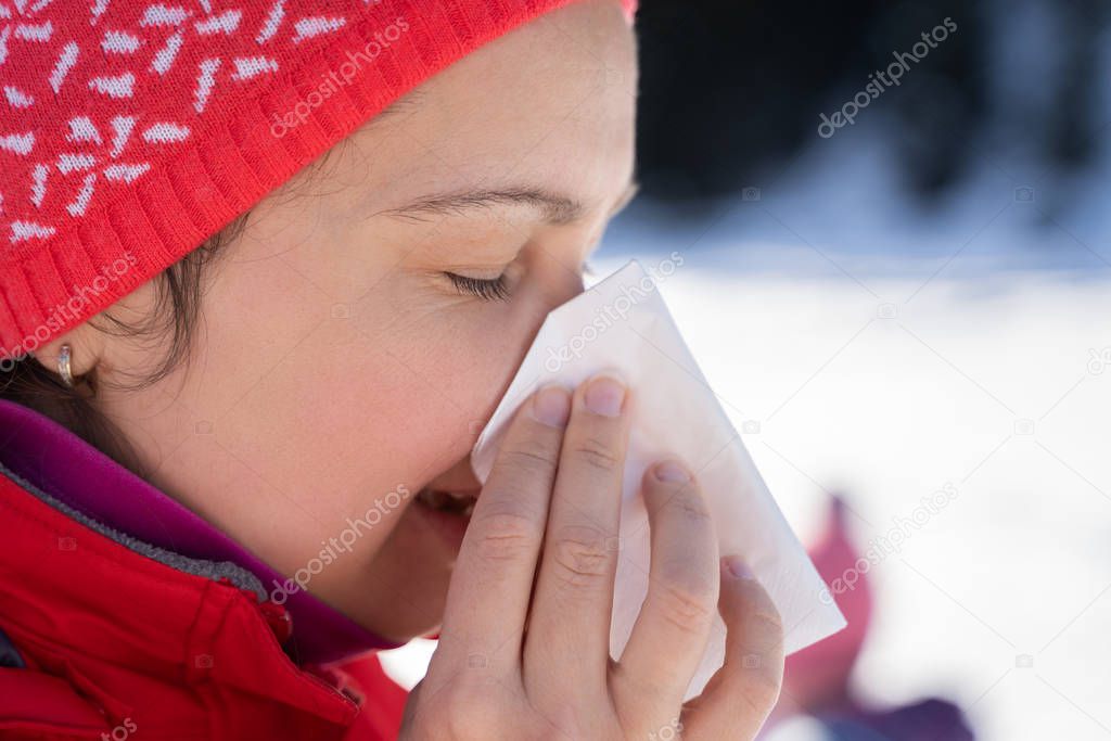 Pretty Young Woman Blowing Her Nose With A Tissue Outdoor In Winter