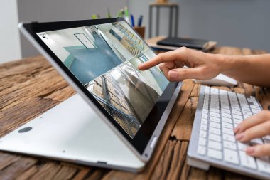 İş kadını laptoptaki kamera görüntülerini kontrol ediyor.