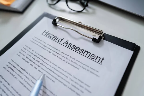 Person Reading Hazard Assessment Document Desk — Stock Photo, Image