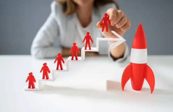 Woman Placing Red Human Figurine Standing On White Increasing Arrow Graph Near Red Rocket