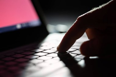 Bir kişinin el dizüstü bilgisayarda yazarak, yakın çekim