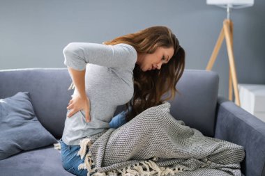 Koltukta otururken sırtı ağrıyan olgun kadın