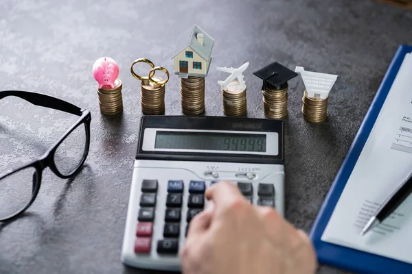 Man Beräkna Kostnader Framför Staplade Mynt Vid Skrivbordet — Stockfoto