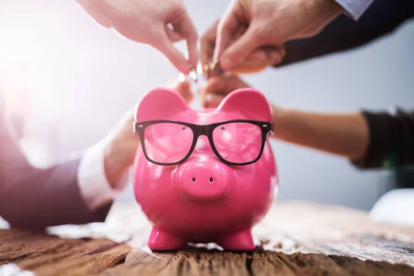 Mano Empresarios Insertando Monedas Pink Piggybank Oficina —  Fotos de Stock