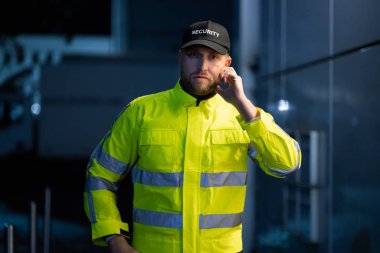 Cam kapı girişinde önünde duran genç güvenlik görevlisi