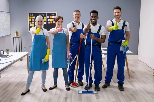 Retrato Felizes Zeladores Diversos Escritório Com Equipamento Limpeza Mostrando Sinal — Fotografia de Stock