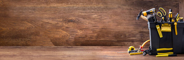 Toolbox With Various Worktools On Wooden Surface