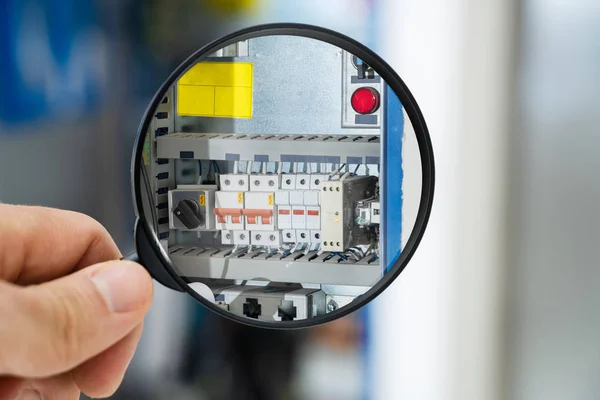 Técnico Masculino Examinando Fusebox Com Lupa — Fotografia de Stock