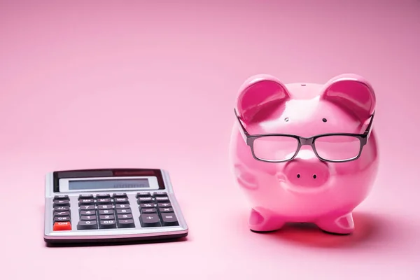 Piggybank Φορώντας Γυαλιά Και Αριθμομηχανή Ροζ Φόντο — Φωτογραφία Αρχείου