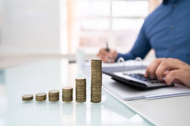 Ofis masasında istiflenmiş bozuk paralarla fatura hesaplayan İşadamı 'nın orta bölümü