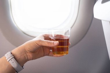 Alkollü içeceği uçağın camının önünde tutmak