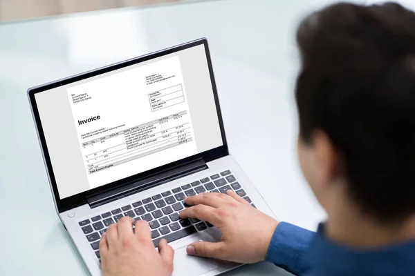 オフィスのノートパソコンで請求書を計算するビジネスマンのクローズアップ — ストック写真