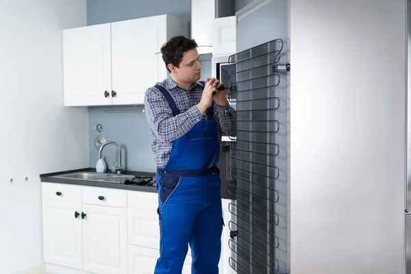 Hombre Trabajador Reparación Refrigerador Con Destornillador Casa —  Fotos de Stock