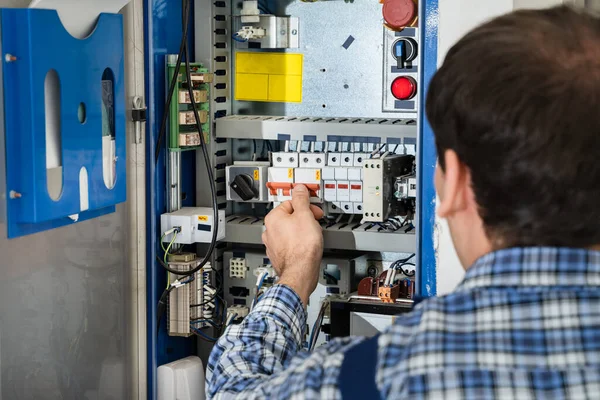 Foto Des Jungen Männlichen Technikers Der Fusebox Untersucht — Stockfoto