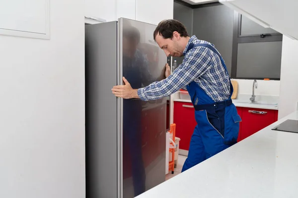 Jeune Déménageur Masculin Plaçant Réfrigérateur Acier Dans Cuisine — Photo