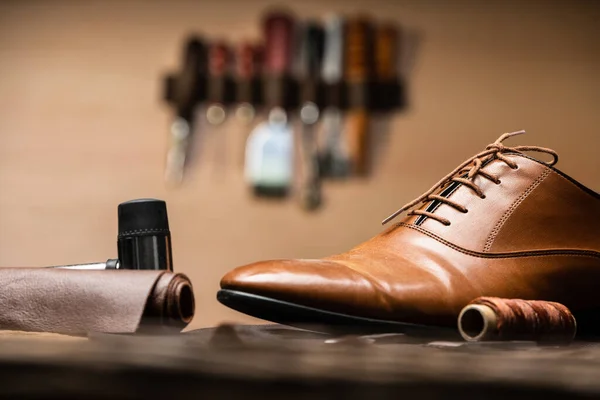 Shoemaker Tools And Finished Shoe On Desk