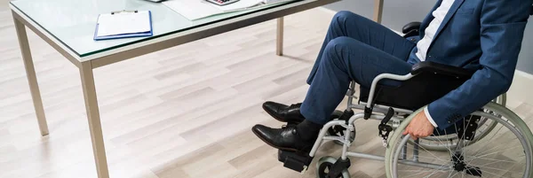 Close-up Of Businessman Sitting On Wheelchair In Office