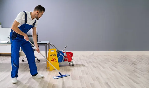 Hombre Con Fregona Señal Suelo Húmedo —  Fotos de Stock