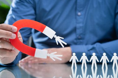 Ahşap masa üzerinde kağıt adaylar çeken mıknatıs closeup