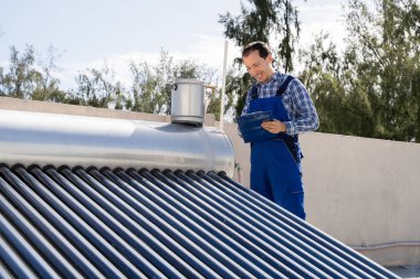 Erkek Tesisatçı Güneş Enerjisi Kazanı Denetlemesi Yapıyor