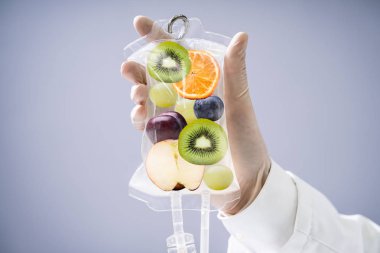 Erkek Doktor Saline Bag 'i hastanenin içinde meyve dilimleriyle tutuyor.