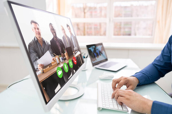 Businessman Video Conferencing With Team On Computer