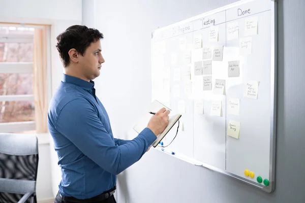 Side View Businessman Writing Sticky Notes Attached White Board Office — стоковое фото