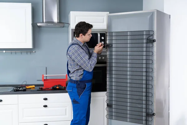 Hombre Trabajador Reparación Refrigerador Con Destornillador Casa — Foto de Stock