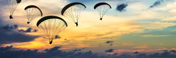 Paraşütler Dramatik Gökyüzü Gün Batımında Karşı Silüeti — Stok fotoğraf