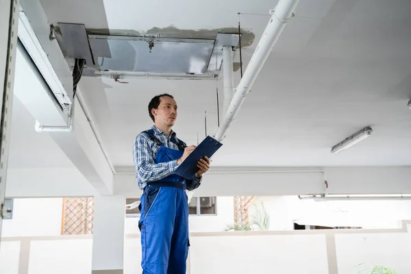 住宅用の鋼管を検査する男性労働者 — ストック写真