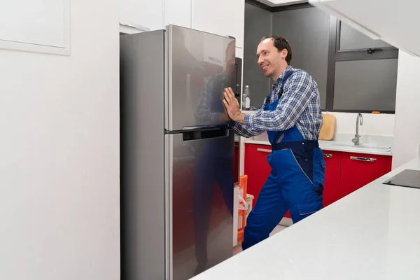 Jeune Déménageur Masculin Plaçant Réfrigérateur Acier Dans Cuisine — Photo