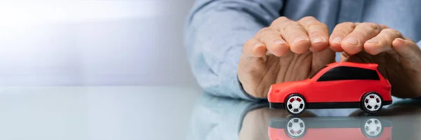 Affärs Mannens Hand Skydda Red Toy Bil Den Reflekterande Desk — Stockfoto