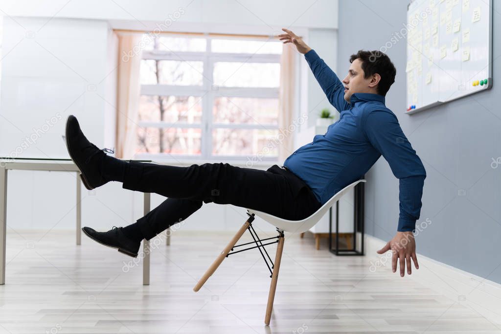 Photo Of Man Falling On Chair In Office