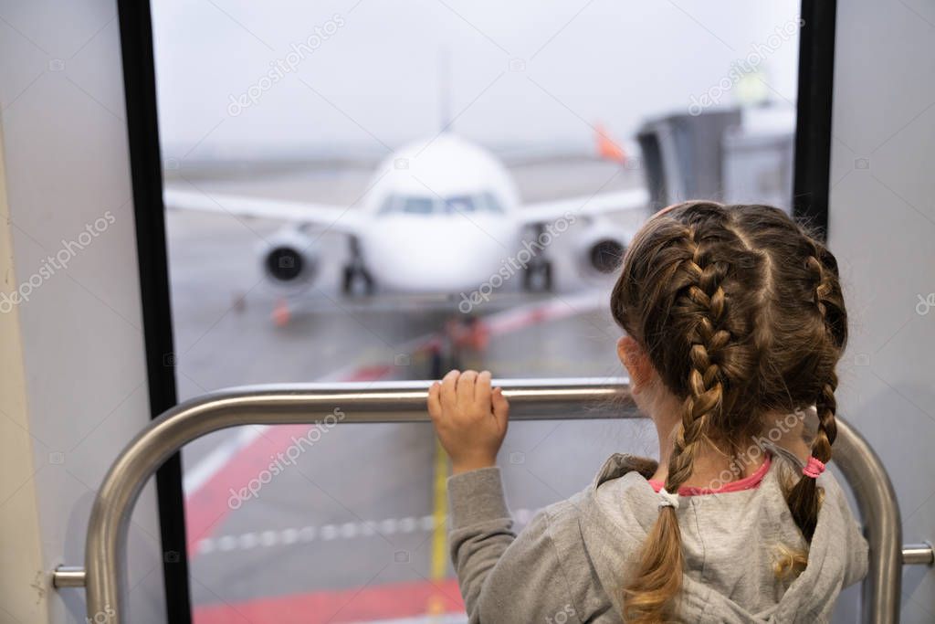 Girl Looking At Airplane Before Boarding For Family Vacation