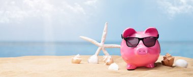 Sahilde siyah güneş gözlüğü ile pembe Piggy banka