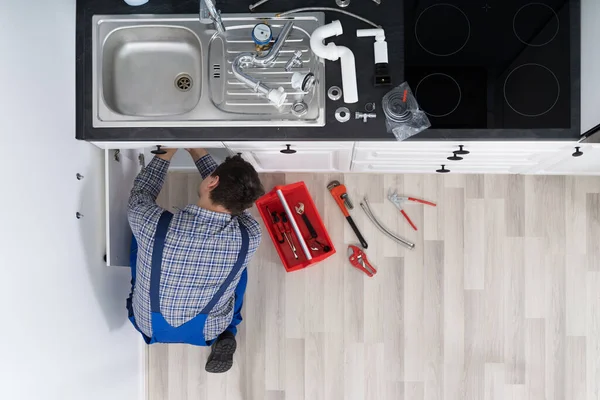 Lavoratore Sdraiato Sul Pavimento Che Ripara Lavandino Della Cucina Con — Foto Stock