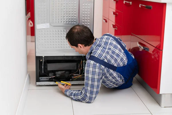 Jeune Serviteur Masculin Réparant Réfrigérateur Cassé Dans Cuisine — Photo