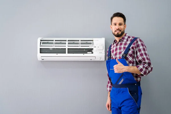 Glad Man Tekniker Gesturing Tumme Upp Nära Luftkonditionering — Stockfoto