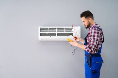 Bir yetişkin erkek teknisyen test ile Klima Dijital multimetre portresi