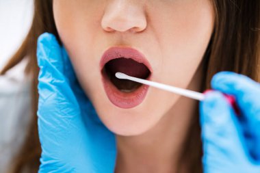 Erkek bir doktorun DNA testi için vücut sıvısı örneği alırken görüntüsü.