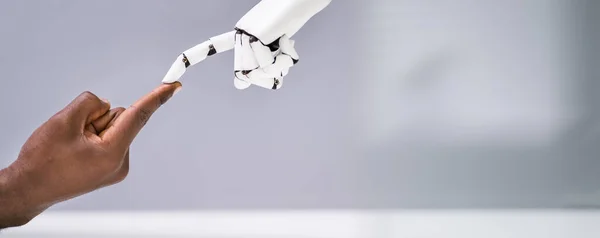 Robot Dotykając Palca Człowieka Szarym Tle — Zdjęcie stockowe