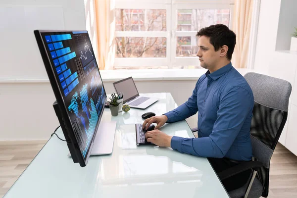 職場におけるコンピュータ上のグラフを分析するビジネスマンの背面図 — ストック写真