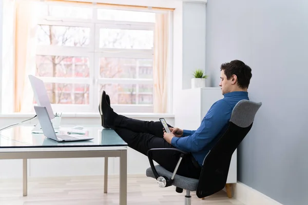 Tired Businessman Relaxing On Chair In Office