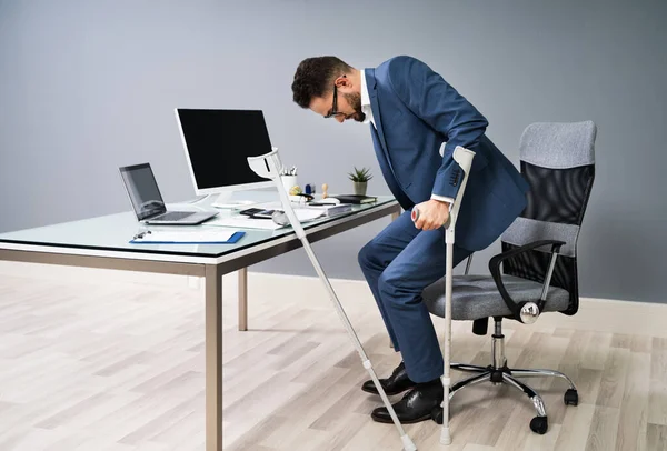 Homem Com Perna Quebrada Usando Fendas Para Levantar Cadeira Escritório — Fotografia de Stock
