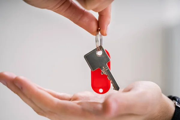 Close Hands Giving Keys Apartment Gray Background — Stock Photo, Image