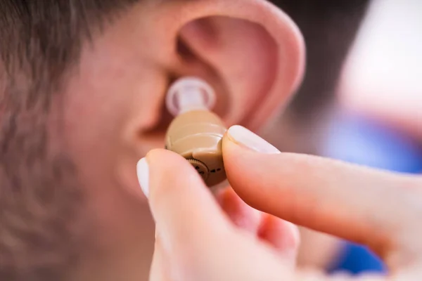 Médico Insertando Audífono Oído Del Hombre Clínica —  Fotos de Stock