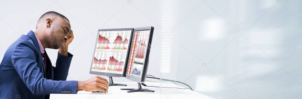 Stock Broker Faced With Financial Loss Looking At Data On Computer