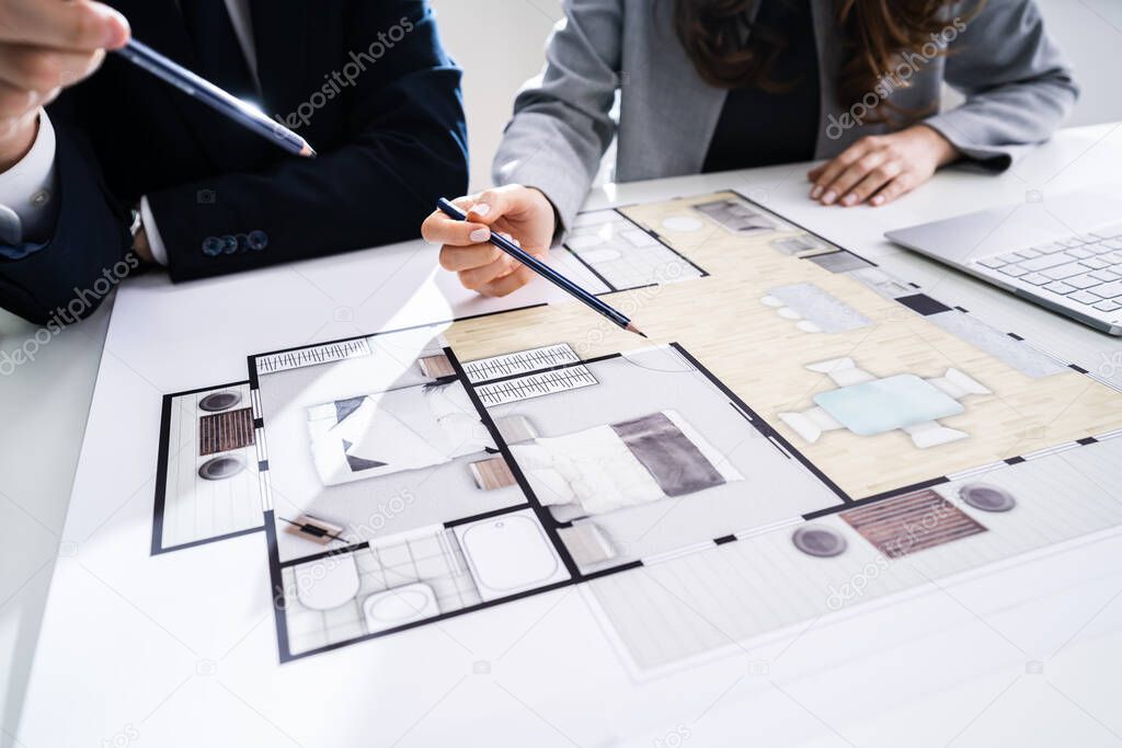 Close-up Of Two Architects Hands Working On Blueprint