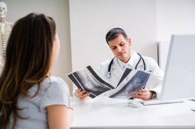 Doktor, hastayla ayak röntgeni hakkında konuşuyor.