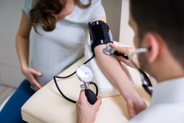 医生在诊所测量孕妇的血压 — 图库照片